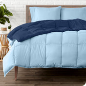 A wooden bed frame with a reversible comforter and sheet set on the mattress