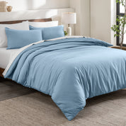 Flannel duvet cover set on a bed in a bedroom with a lamp and plant in the background.