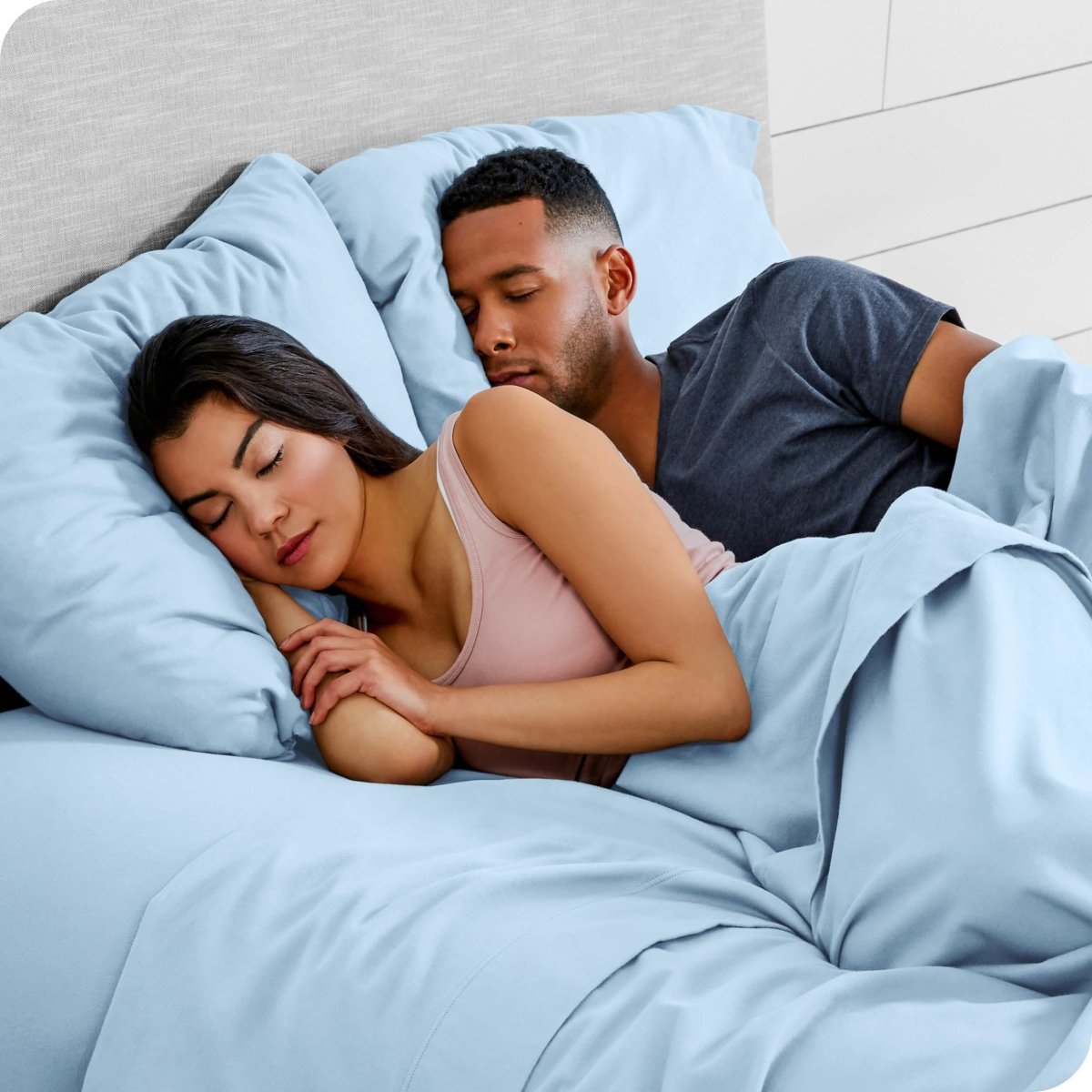 A couple sleeping with their heads resting on pillows with flannel pillowcases on them