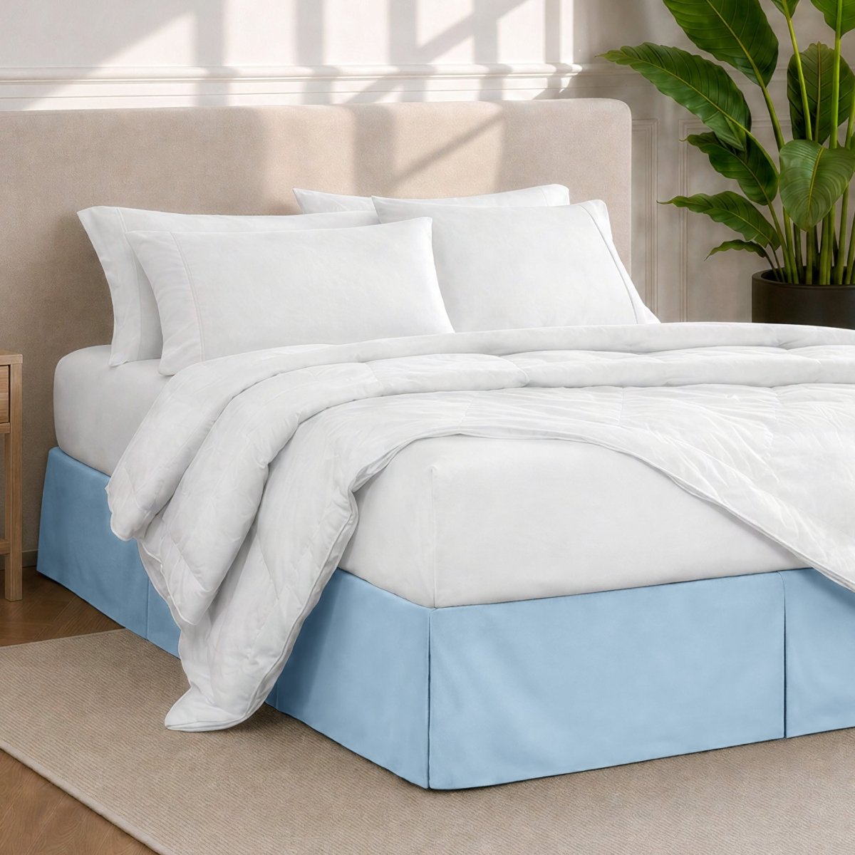 A modern bedroom with a bed skirt, comforter and sheets on the bed