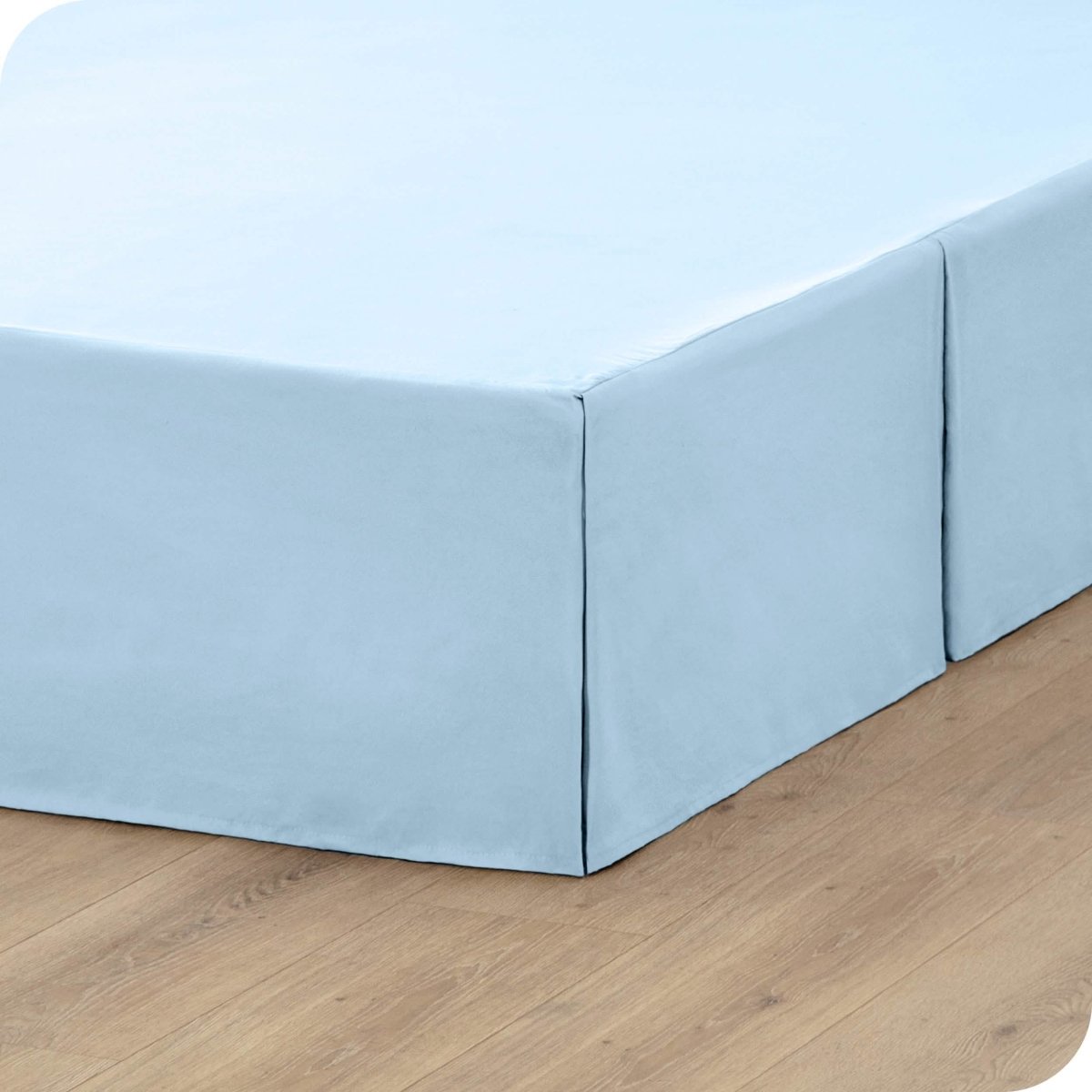 A box spring with a bed skirt on it