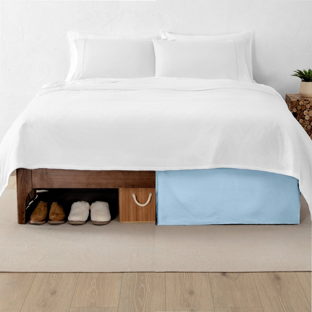 One side of a bed has shoes and a box under it while the other side has a bed skirt so that under the bed is hidden from view
