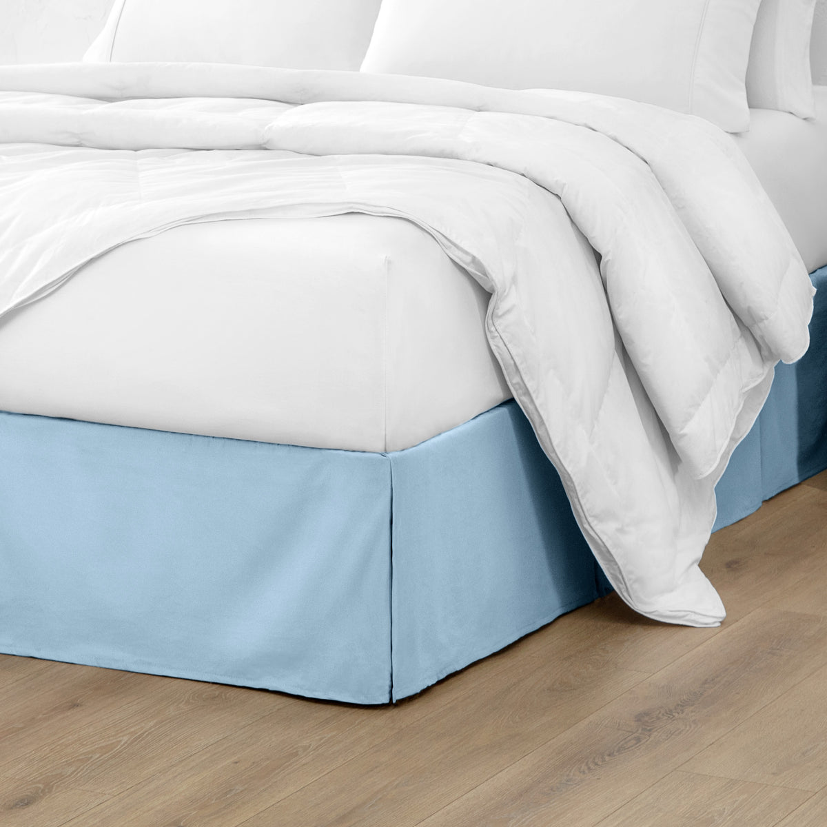 Microfiber bed skirt on a bed with white bedding and wooden floor.