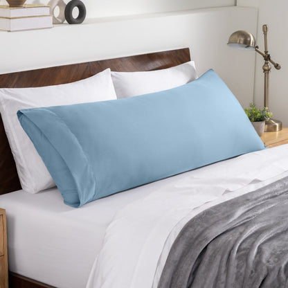 Bed sheets and pillows on a neatly made bed with a wooden headboard.