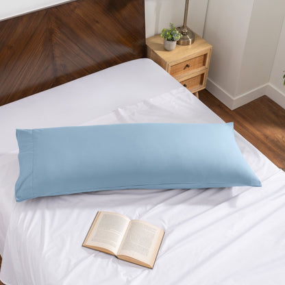 Pillowcase on a body pillow with a wooden headboard and plant in the background