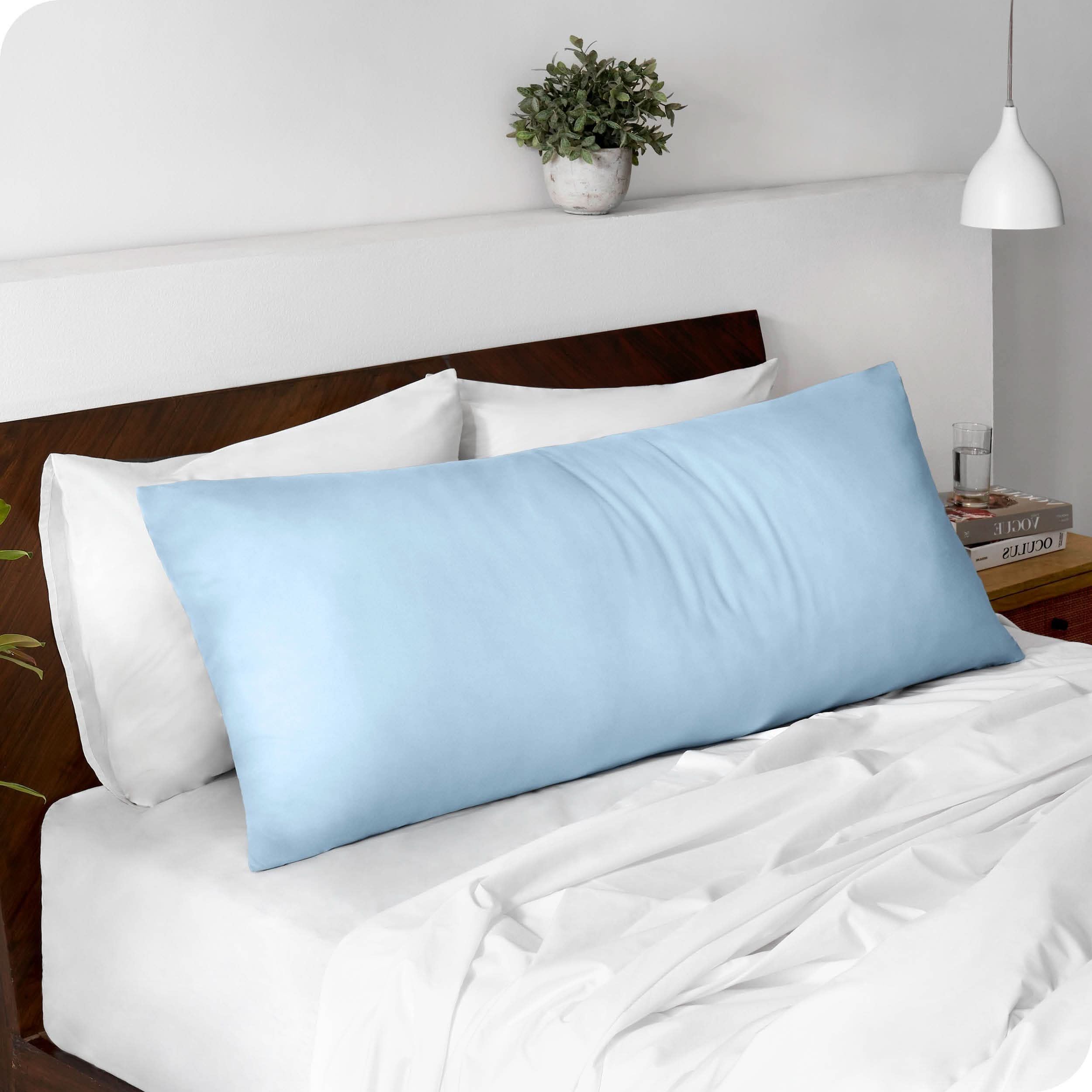 A body pillowcase on a pillow set against a headboard