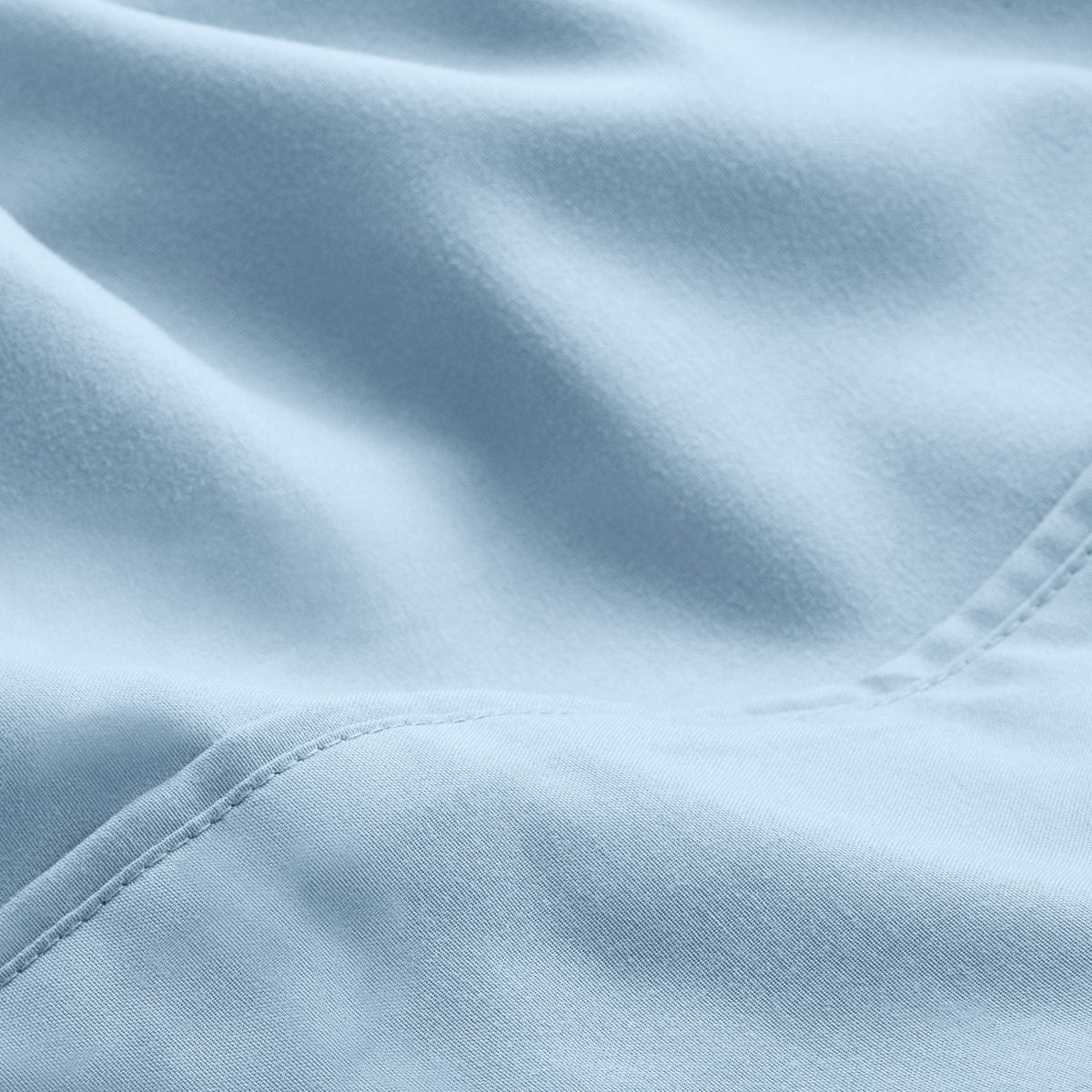 A close-up of microfiber fabric with soft folds and a visible stitched seam.