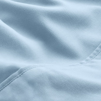 A close-up of microfiber fabric with soft folds and a visible stitched seam.