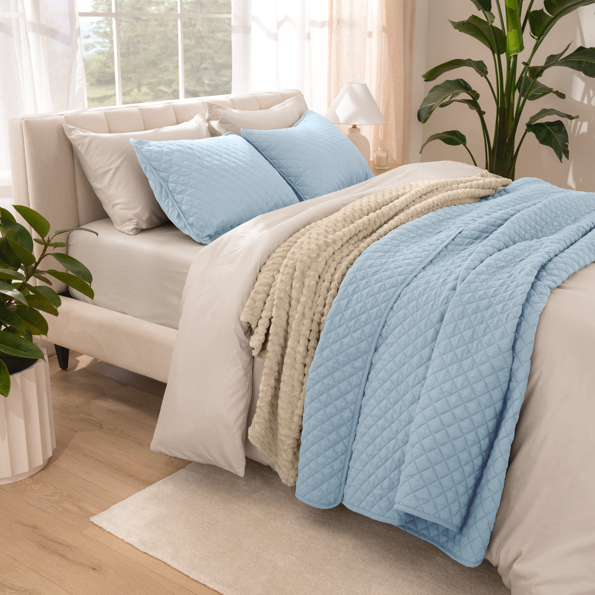Side view of bed with coverlet set draped on a bed made with a duvet set