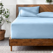 A bed with a fitted sheet and matching pillowcases