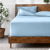 Wooden bed with ultra soft bedding in a minimalistic room.