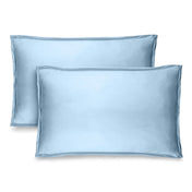 Two blue pillow shams on pillows standing up with one behind the other