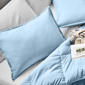 Microfiber pillow sham set on a bed with a magazine on top of the comforter.