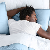 Man sleeping with his head resting on a pillow sham