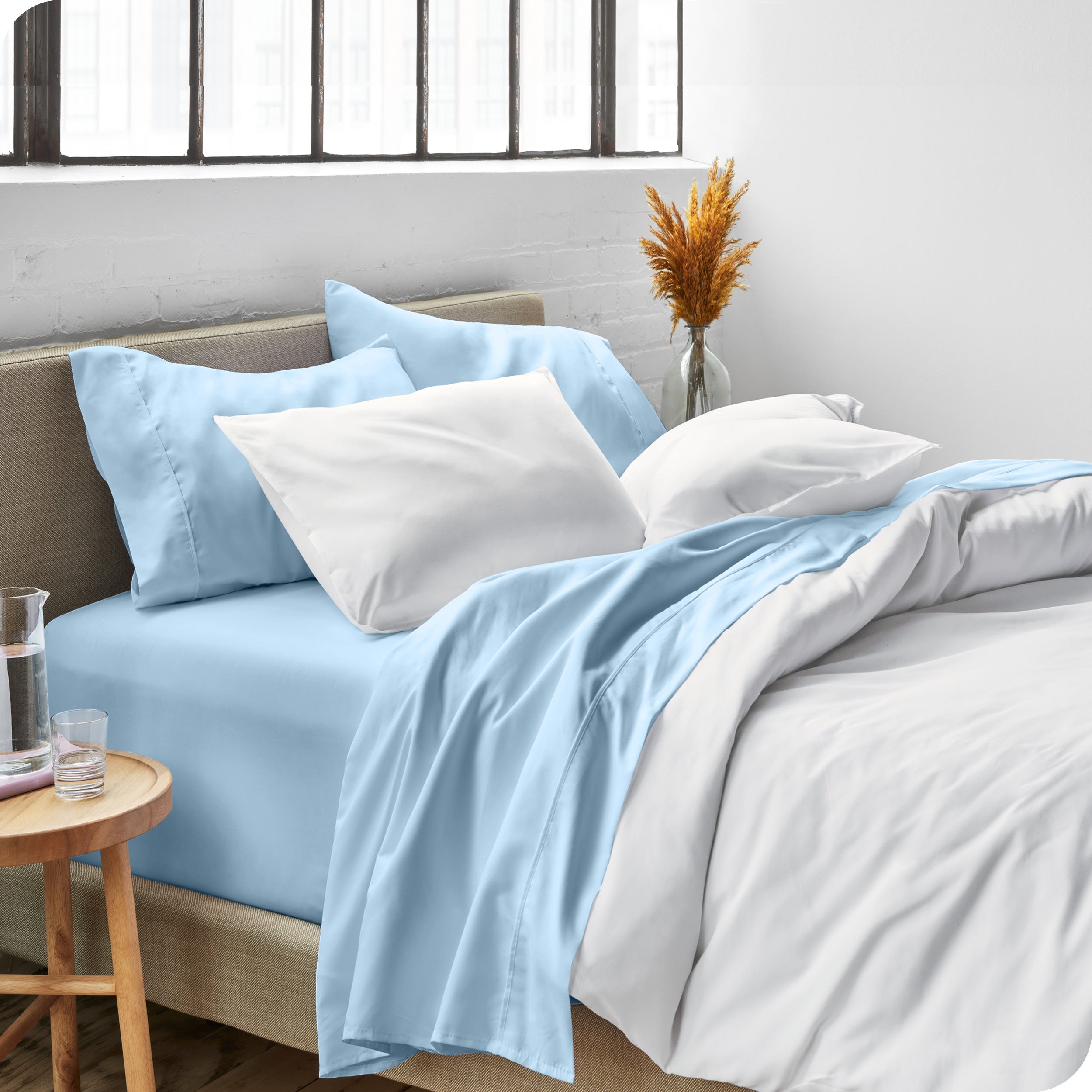 Sheets and a duvet cover on a bed in a bright bedroom