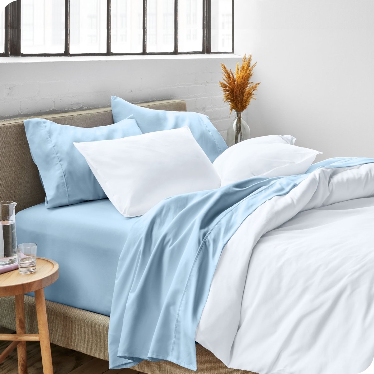 A side view of a bed made with microfiber sheets and a white duvet cover