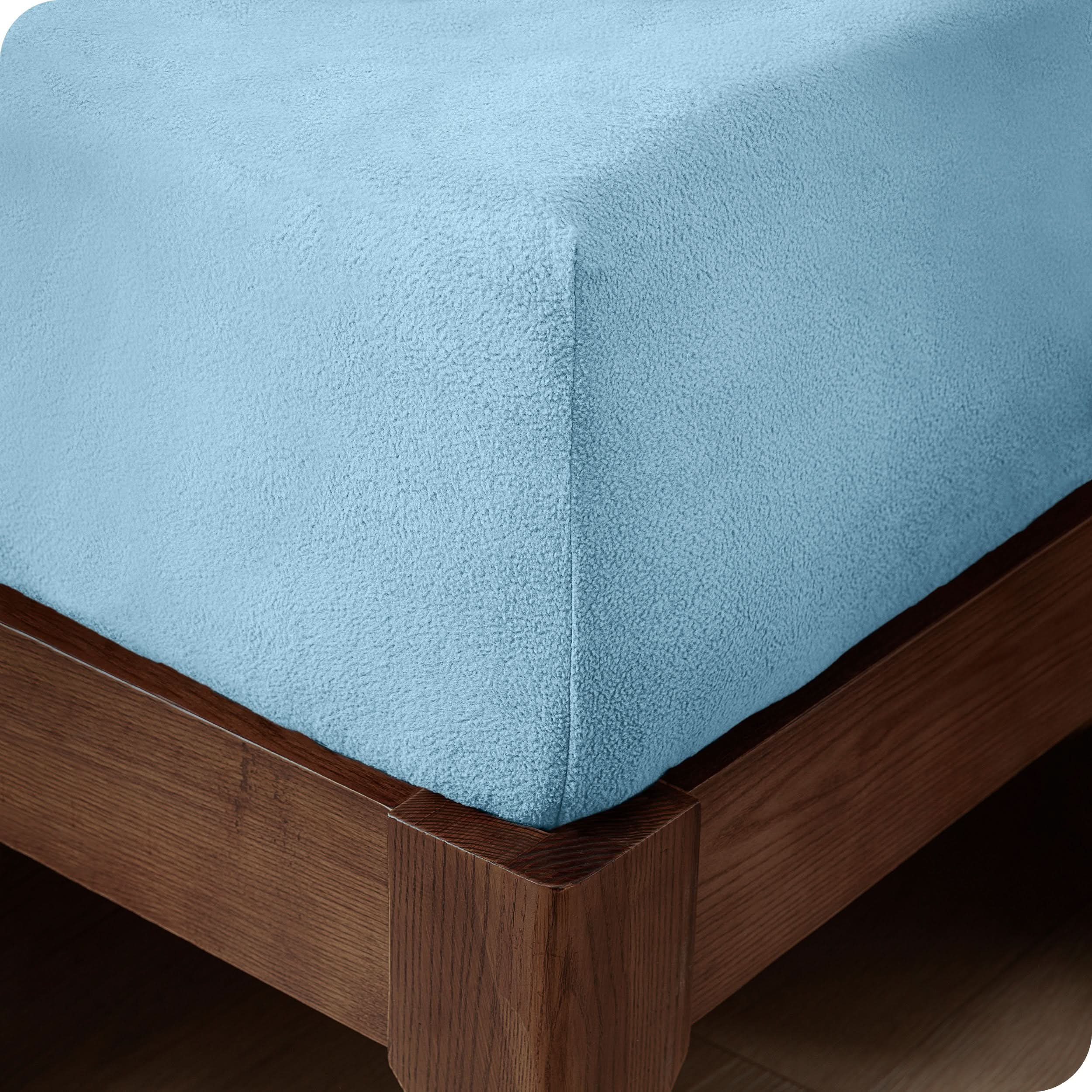 A corner of a modern bed with a polar fleece fitted sheet on.