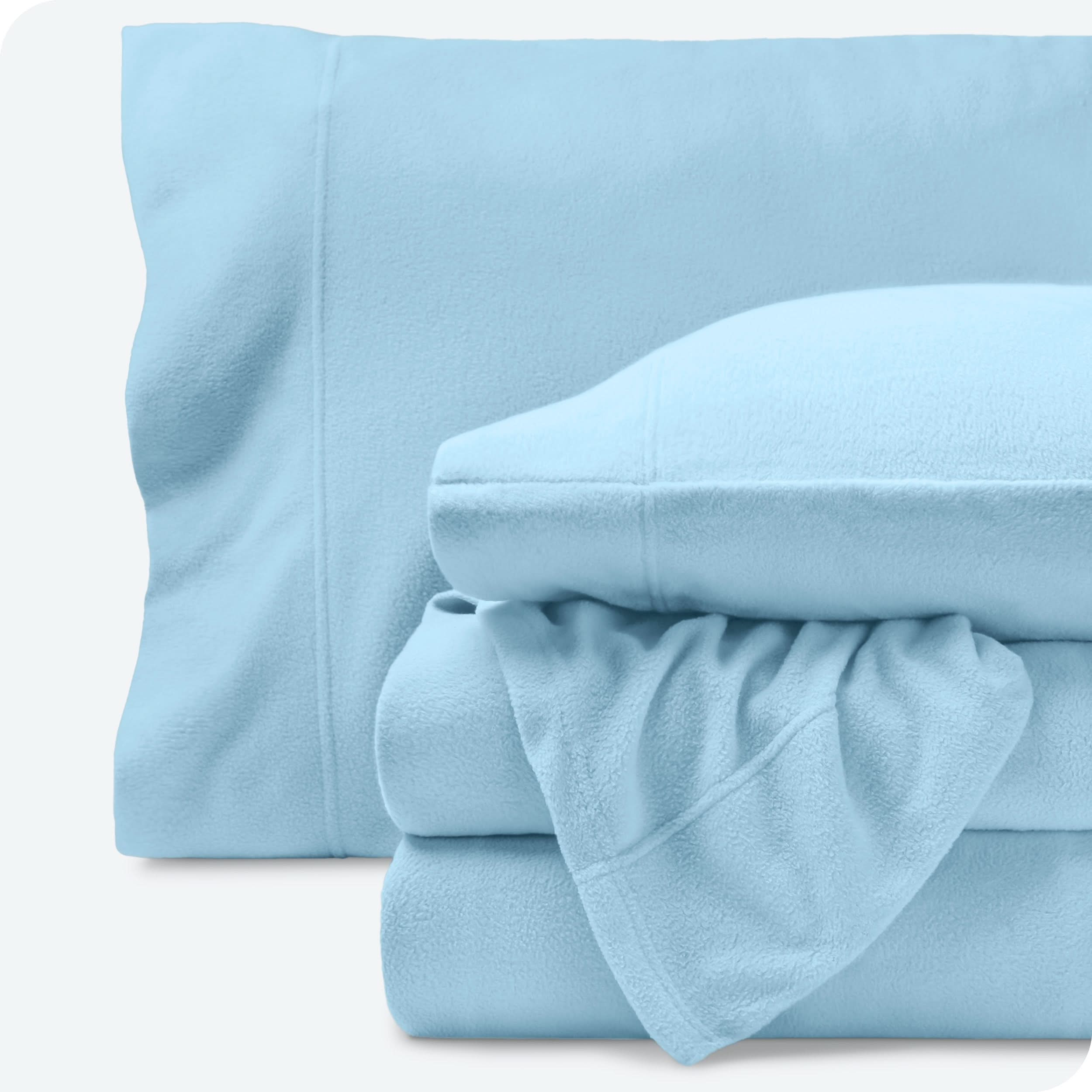 Fleece sheets folded neatly and stacked with pillows inside the pillowcases