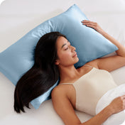 A woman is sleeping on a pillow with a satin pillowcase