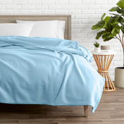 Light blue polar fleece blanket on a bed