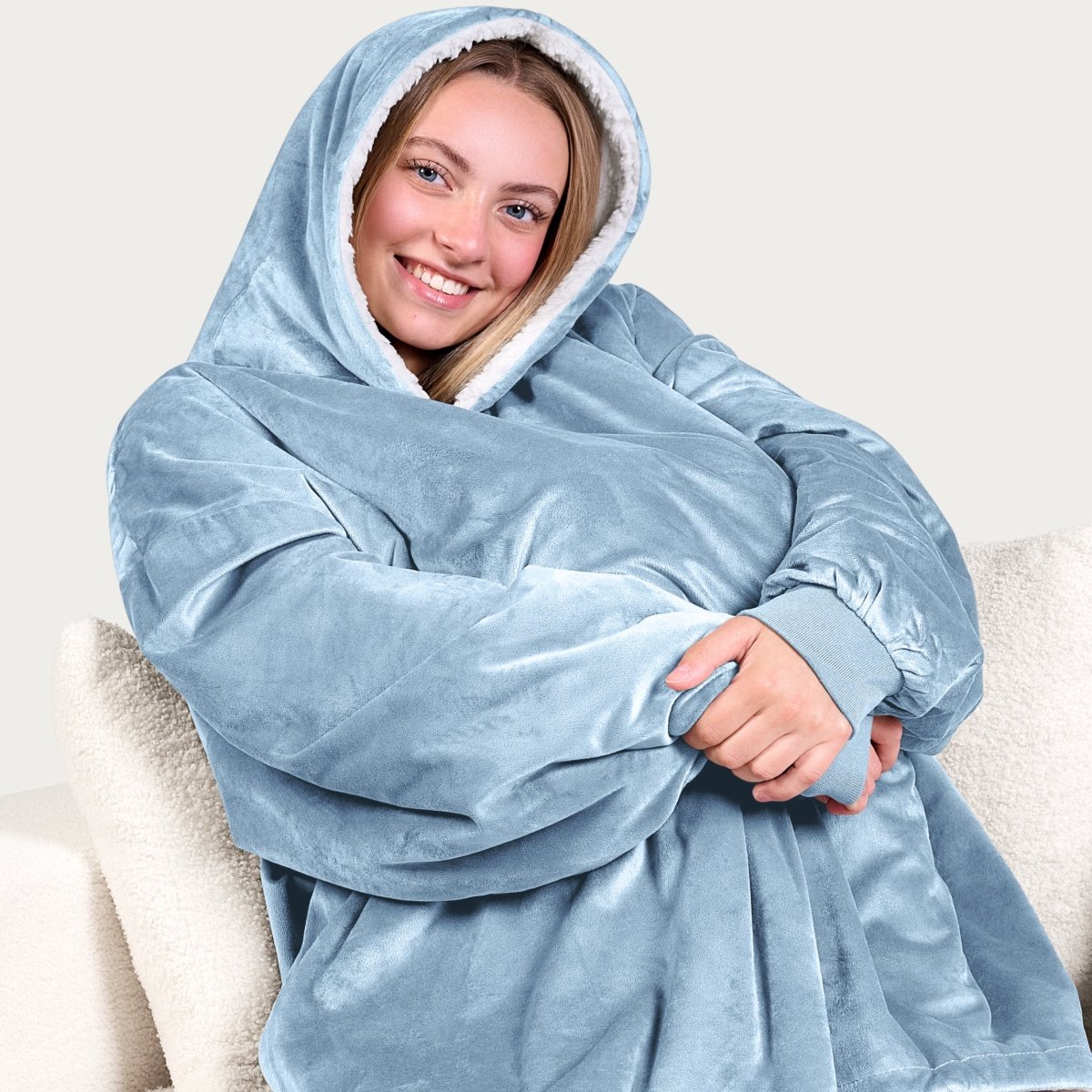 An adult with a hooded wearable blanket on