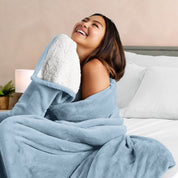 A woman smiling while wrapped in a sherpa blanket