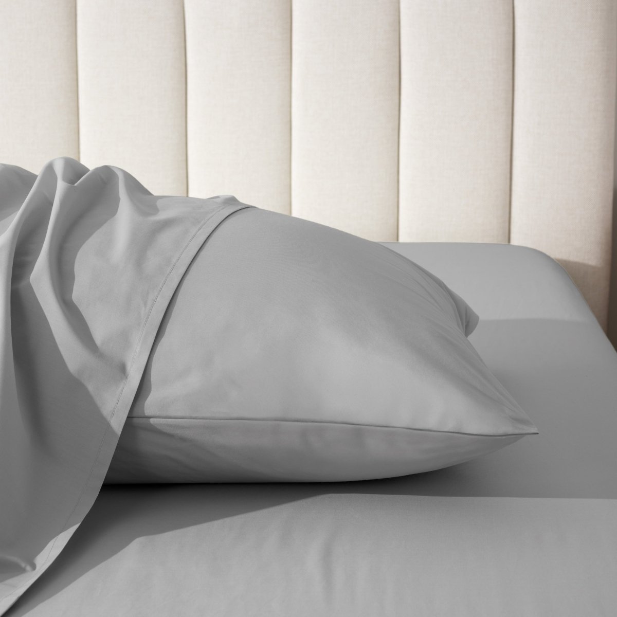 Pillow on a bed with a neutral headboard