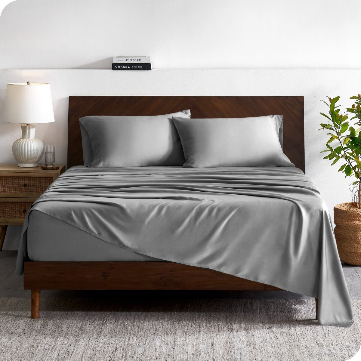 A contemporary bed with a sheet set and a wooden headboard.
