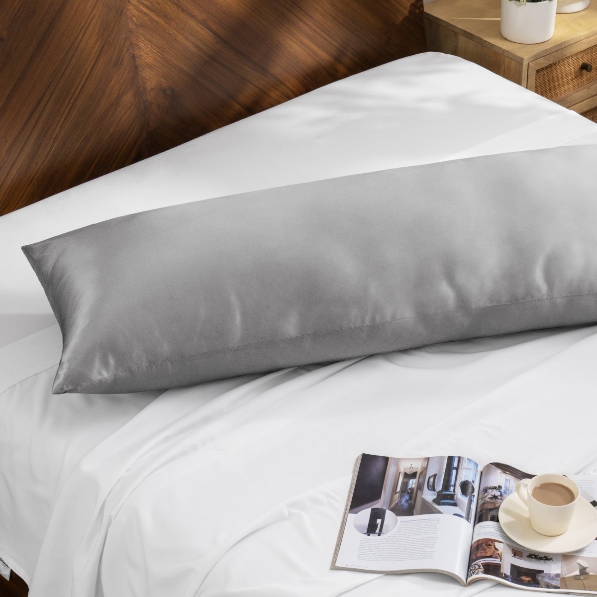 Bamboo pillow on a bed with a magazine and cup of coffee on a wooden nightstand.