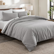 Flannel duvet cover set on a bed in a bedroom with a lamp and plant in the background.