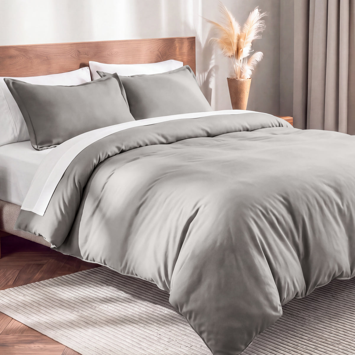 Flannel duvet cover set on a bed in a bedroom with a lamp and plant in the background.