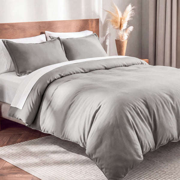 Flannel duvet cover set on a bed in a bedroom with a lamp and plant in the background.