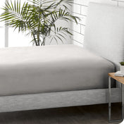 A sideview of a modern bed with a flannel fitted sheet.