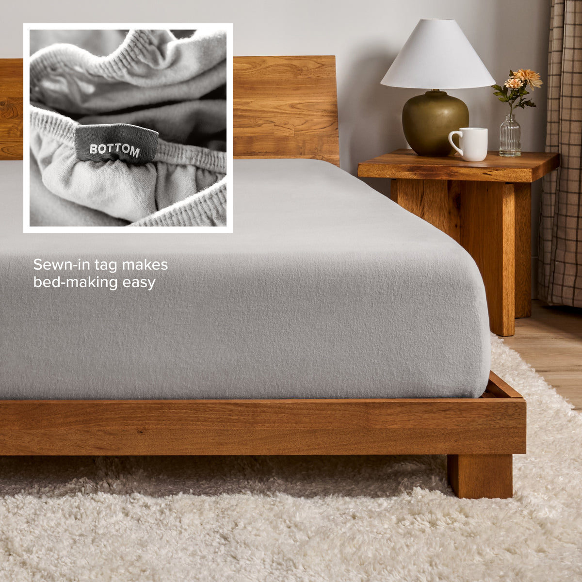 A flannel fitted sheet on a mattress with a wooden bed frame