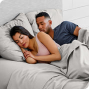 A couple sleeping with their heads resting on pillows with flannel pillowcases on them