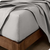 Close up of the corner of a mattress with a flannel fitted sheet and flat sheet on it