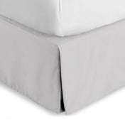 Bed skirt on a bed with white bedding