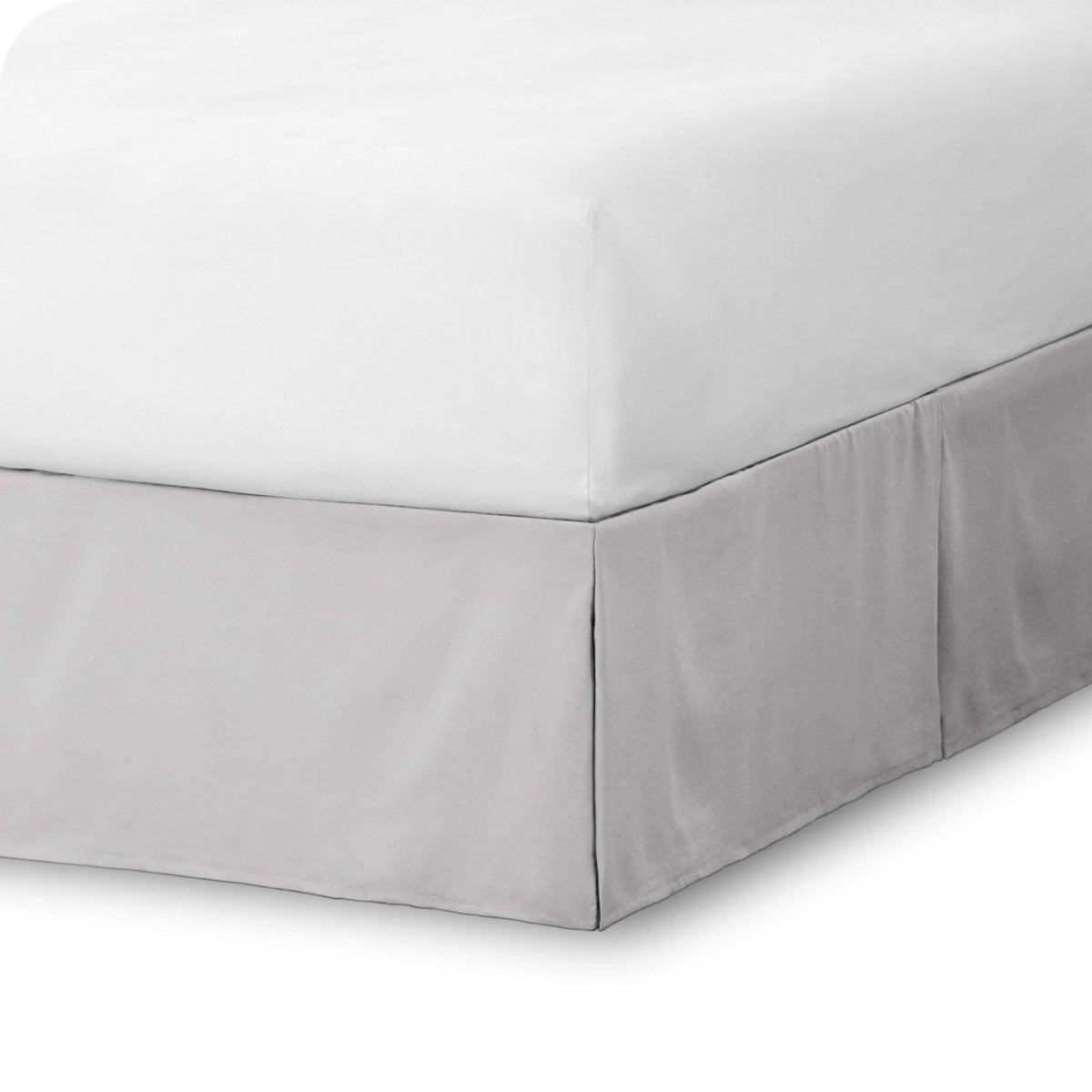 The corner of a bed skirt on a bed frame