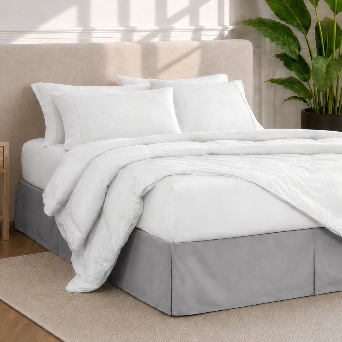 A modern bedroom with a bed skirt, comforter and sheets on the bed