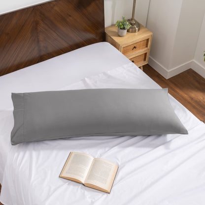 Pillowcase on a body pillow with a wooden headboard and plant in the background