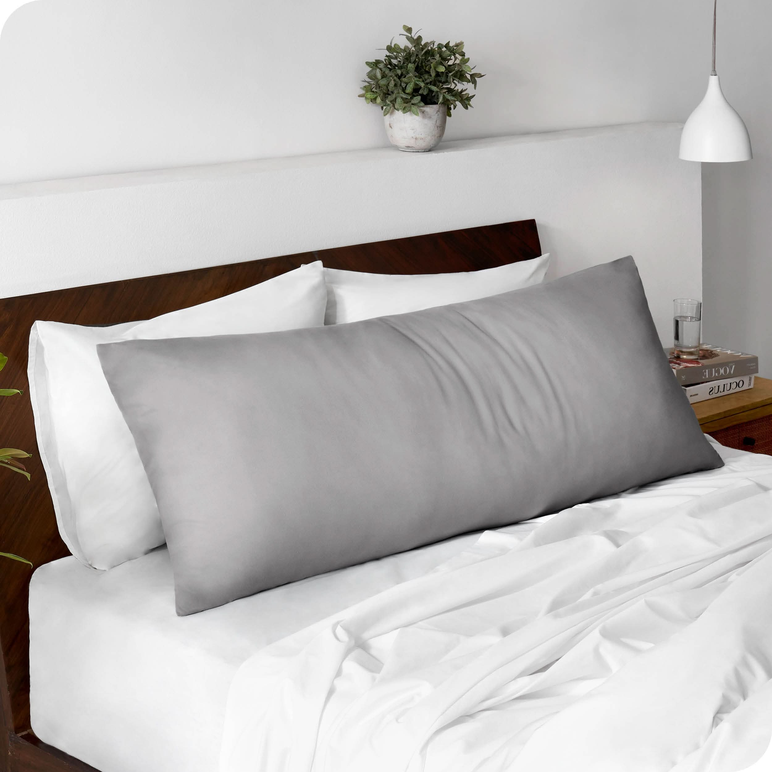 A body pillowcase on a pillow set against a headboard