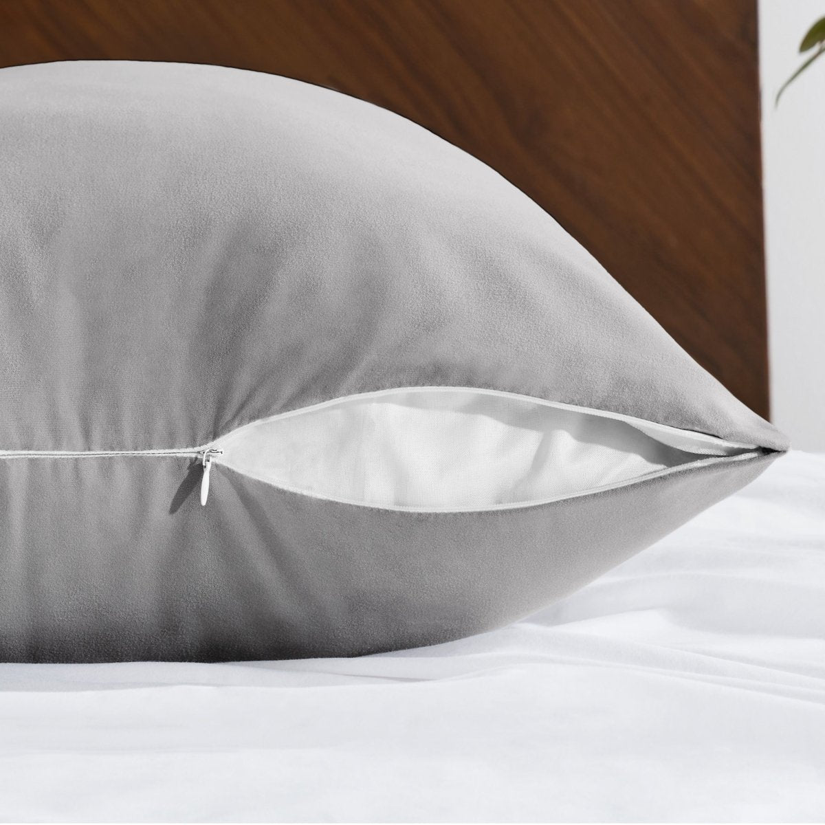 Body pillowcase with a zipper closure on a bed with a wooden headboard