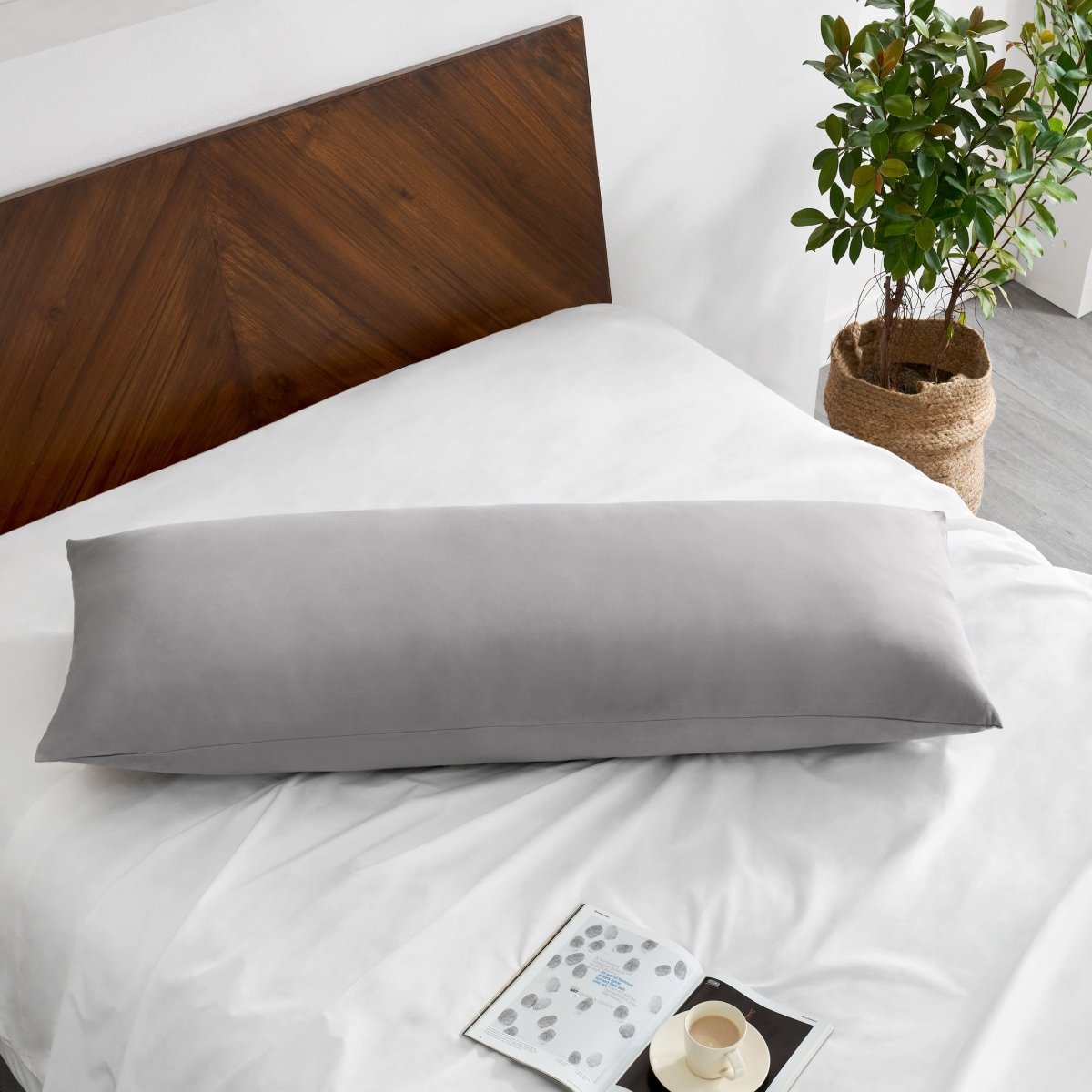Pillowcase on a body pillow with a wooden headboard and plant in the background