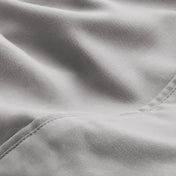 A close-up of microfiber fabric with soft folds and a visible stitched seam.