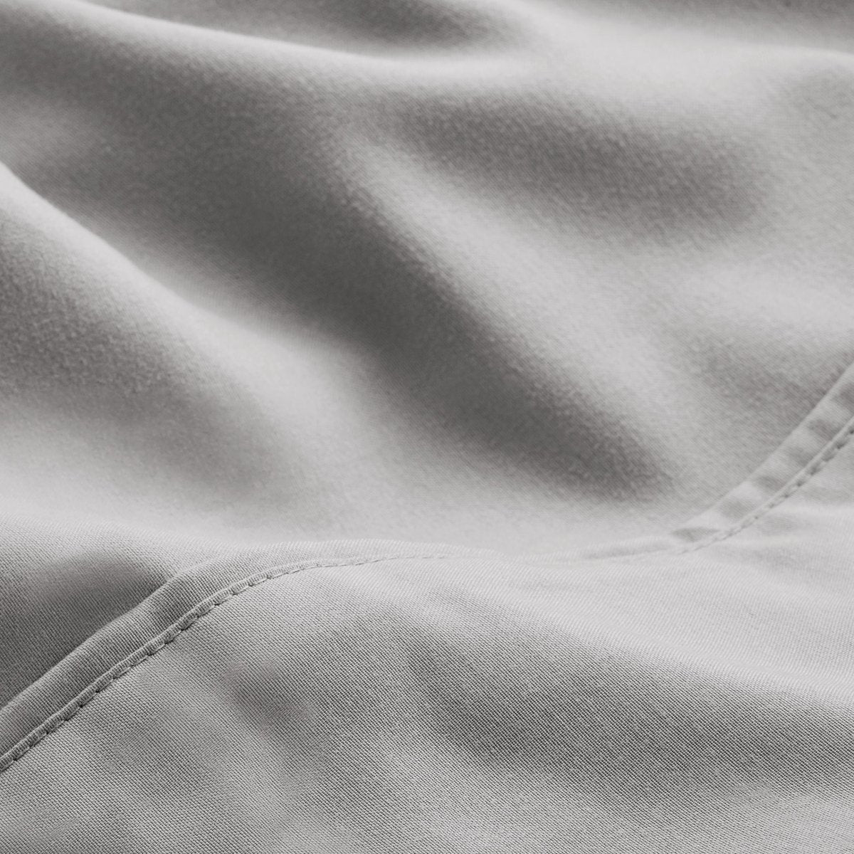 A close-up of microfiber fabric with soft folds and a visible stitched seam.