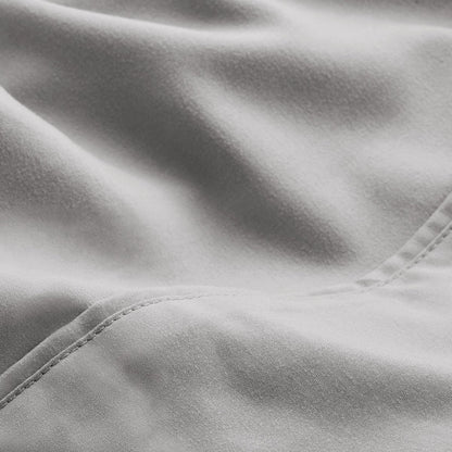 A close-up of microfiber fabric with soft folds and a visible stitched seam.
