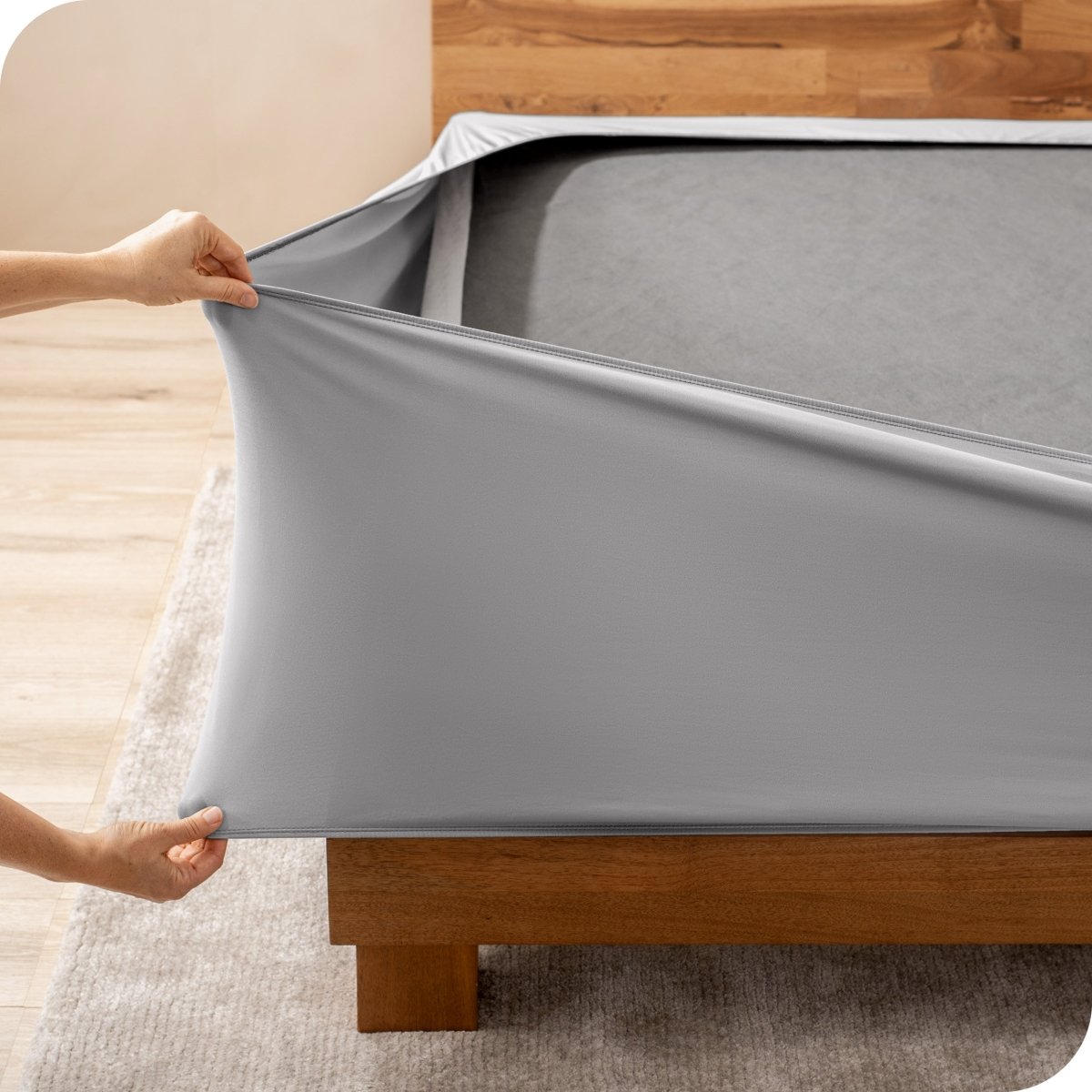 A person stretching a box spring cover