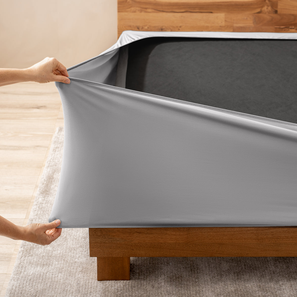 A person stretching a box spring cover