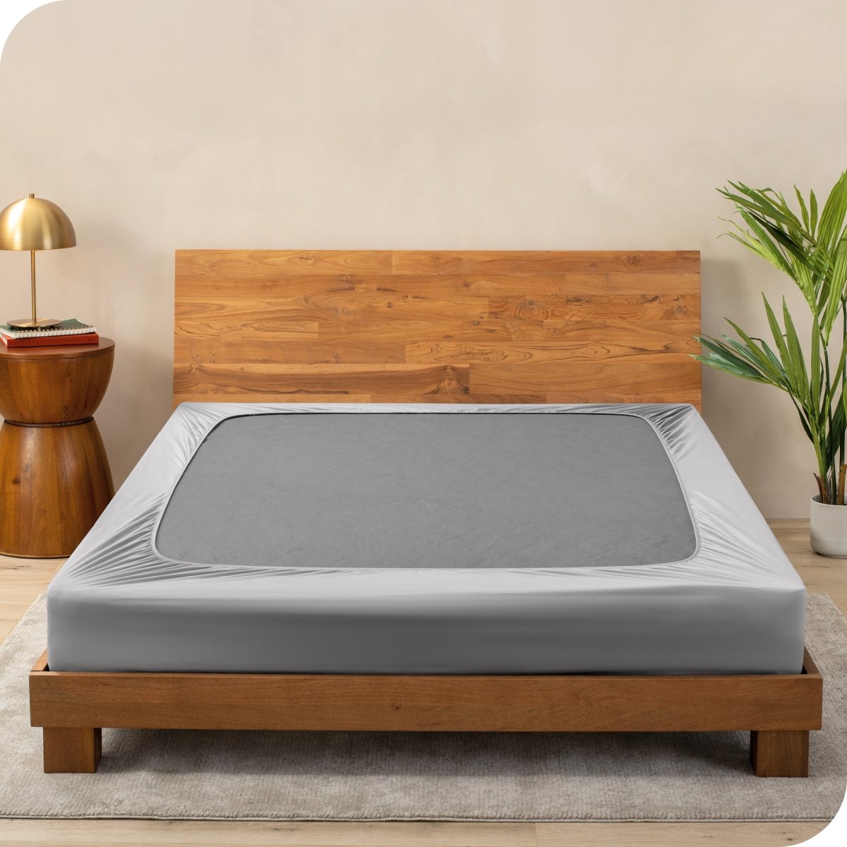 A cover on a box spring set on a wooden bed frame