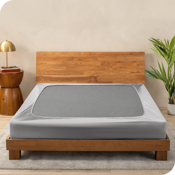 A cover on a box spring set on a wooden bed frame